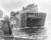 A photo of a Coast Guard manned LST approaching a beach.